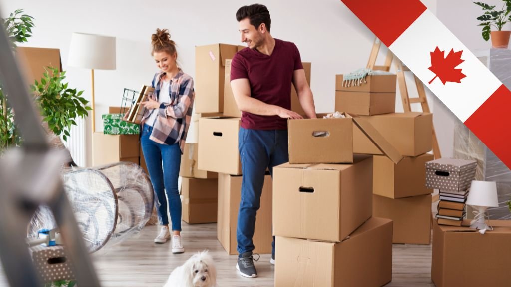 Pareja joven cargando cajas mientras se mudan a su nuevo hogar en Canadá
